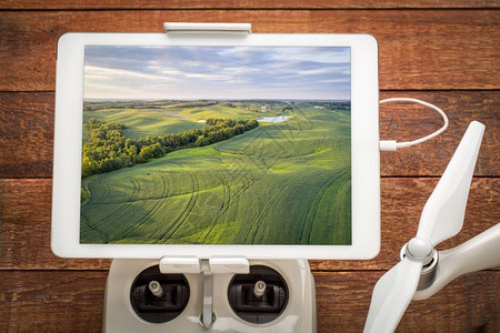 密苏里州的绿豆田审查在无人机线电控制器上安装的数字平板上空中图像图片