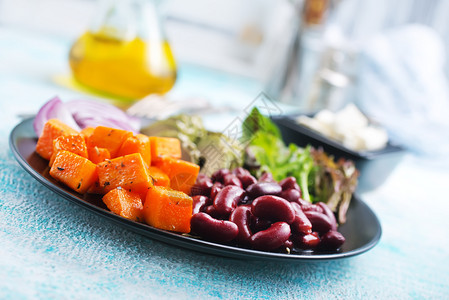 沙拉烤南瓜鳄梨和黑盘上红豆的成分图片