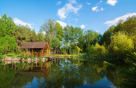日出时的木环房子和池塘图片