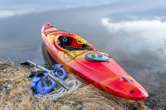 湖岸白水皮艇带划桨和防水的便衣在科罗拉多北部初春风景图片