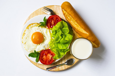 面包炒鸡蛋牛奶和蔬菜以及白底煎番茄饼早餐图片