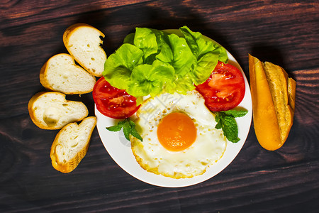 面包炒鸡蛋牛奶和蔬菜早餐以及木本面的煎番茄饼图片