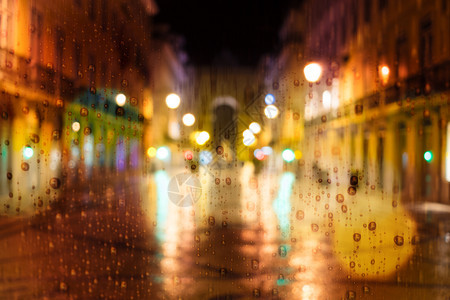 晚上在城里下雨街上交通车和城市灯光图片