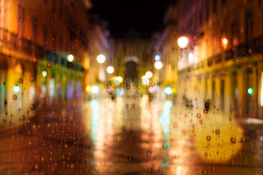 晚上在城里下雨街上交通车和城市灯光图片