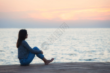 一个女人在日落时海滩观晒太阳的轮光图图片