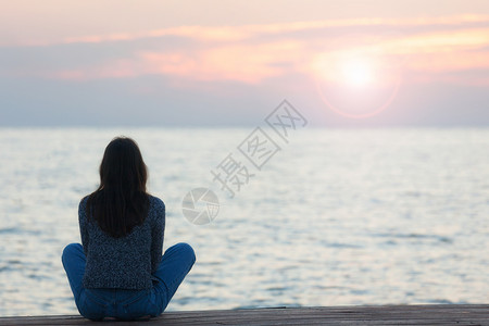一个女人在日落时海滩观晒太阳的轮光图图片