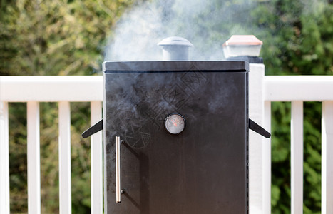 靠近一个煮饭的烟民背景是树林关闭一个烟民来自烤肉的新鲜烟民图片