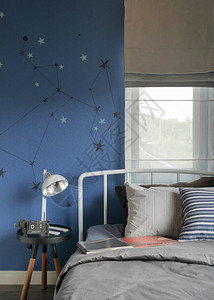 现代式床铺和蓝墙卧室的Beige和现代型床铺及薄膜上带条纹枕头的Beige和条纹枕头图片