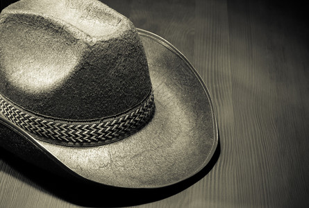 戴在木材上的牛仔帽戴在木制背景上的牛仔帽图片