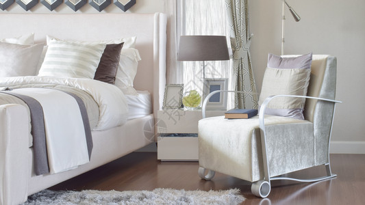 现代卧室内手椅和床边有灰色枕头现代卧室内手椅和床边桌灯上有灰色枕头图片