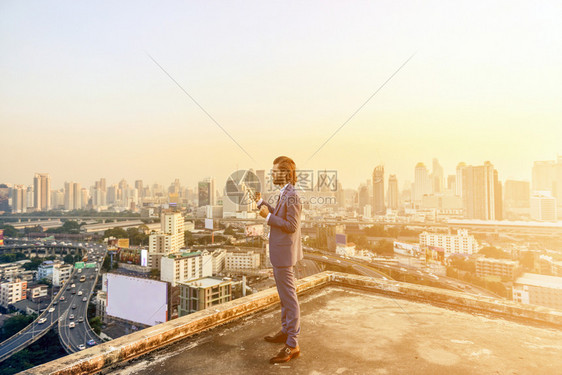 日落时看曼谷市的西方商人图片