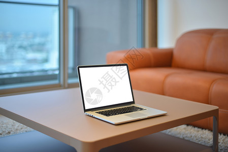 现代客厅桌上的手提电脑带空白屏幕图片