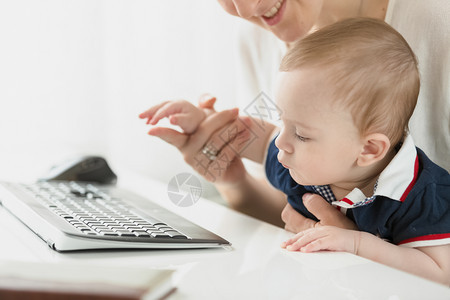 小婴儿男孩在办公室键盘上看小婴儿男孩在办公室键盘上看小婴儿男孩在办公室键盘上看小婴儿男孩的近镜头照片图片
