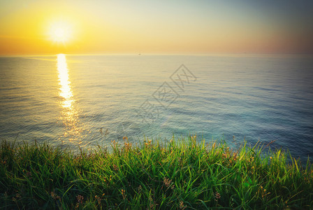 日落成份天空海洋绿草图片