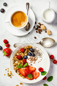 健康早餐咖啡和一碗自制麦片加酸奶和新鲜果子白大理石背景顶端平地健康早餐咖啡酸奶面粉和浆果健康早餐咖啡面粉和浆果背景图片