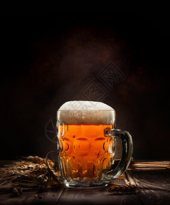 啤酒在杯子里木桌上黑色背景图片