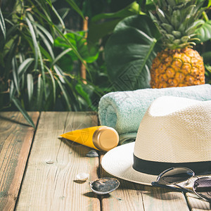 暑假概念白帽海滩毛巾防晒霜太阳镜和热带水果图片