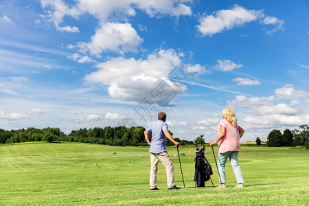 活跃的老年夫妇在夏季打高尔夫退休活动跃的老年夫妇在上课打高尔夫图片