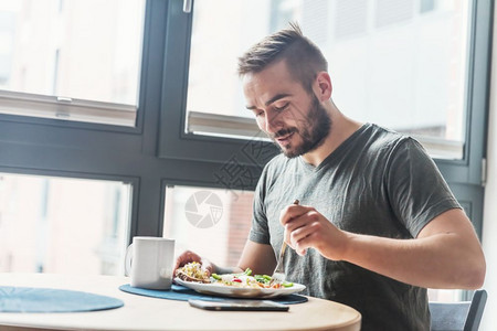 男人吃健康的早饭在家里吃餐健康的生活方式健康的早餐图片