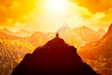 日落时在云顶的山上坐着瑜伽姿势Zen默思和平在日落时坐着瑜伽姿势图片