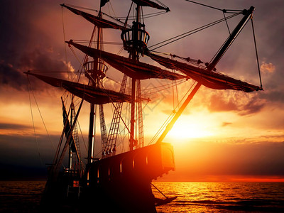 古老的海盗船在日落时和平的海洋上静波浪反射日落时图片