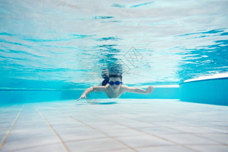 在水下游泳的年轻男孩有游泳护目镜水公园休闲活动在水下游泳的年轻男孩在水下游的年轻男孩在水下游泳中的年轻男孩图片