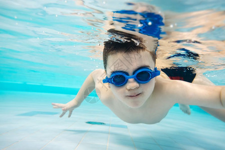 小男孩在游泳池里潜水休闲活动上公园图片