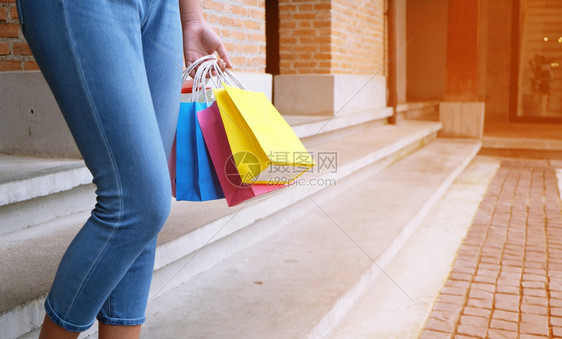 亚洲女孩持有销售袋的购物中心消费主义生活方式概念图片