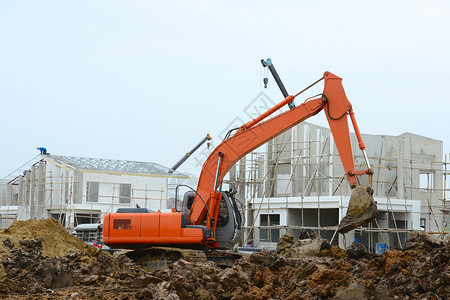 在新住房建筑项目中工作的挖掘机图片