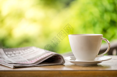 早上好咖啡杯加关于花园中自然绿色背景的报纸背景图片