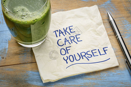 照顾好你自己鼓舞人心的笔迹在餐巾纸上与一杯绿色果汁图片