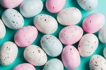 一群多彩的糊蛋产在绿宝石背景上复活节传统蓝色背景的多彩糊蛋图片