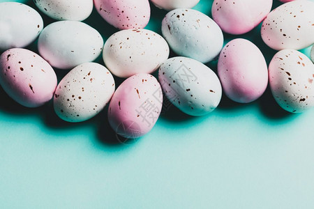 一群彩色的鸡蛋产在面粉蓝色背景上复活节糖果制空间彩色的鸡蛋图片