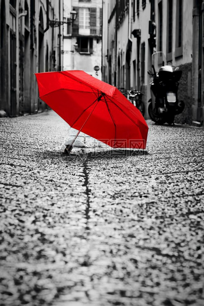 红伞在旧城的科布斯通街上风雨暴天气黑白概念思想理传统回溯风格的颜色红伞在旧城的科布斯通街上风和雨图片