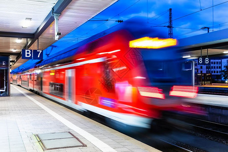 具有创意的抽象铁路旅行和运输工业概念现代红色高速电动客上乘双层火车晚上在照亮的火车站平台运动效果模糊图片