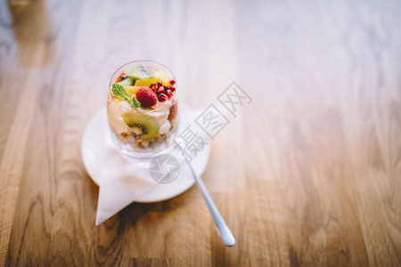在木制桌边的杯子上加水果和燕麦的健康甜点配餐饭图片