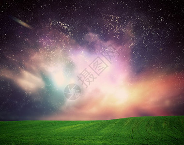 梦幻星系天空下的绿草地宇宙之光梦幻星系天空下的绿草地间闪耀的恒星图片