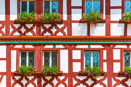 传统的中世纪德国半铁板的建筑墙有彩色玻璃窗和花盆图片