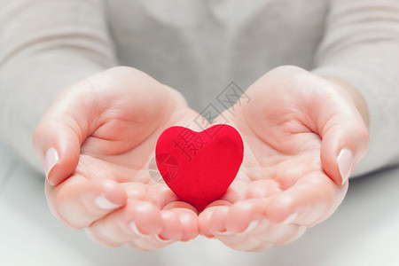 妇女中的小红心和手在施舍保护健康生命爱的象征妇女中的小红心和手在施舍保护图片