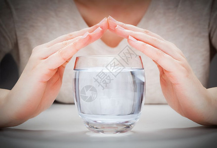 妇女与手覆盖的清洁矿泉水一杯环境保护概念健康饮品妇女与手覆盖的清洁矿泉水一杯图片