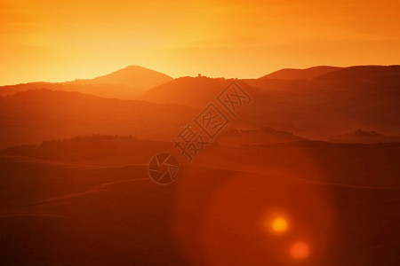 意大利日出时的托斯卡纳风景山丘葡萄园太阳耀斑图片