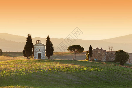 日出时托斯卡纳风景与圣奎里科和奥尔西亚的圣奎里科德和尔斯小教堂日出时托斯卡纳风景与意大利马登纳和维塔的小教堂图片