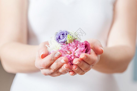 妇女手中的鲜花美容和温泉的概念保健芳香疗法等保健图片