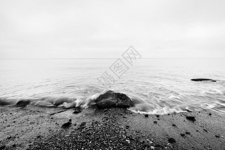 怀旧的海中间岩石被波浪击中黑白的远地平线怀旧的海中间岩石被波浪击中黑白的图片