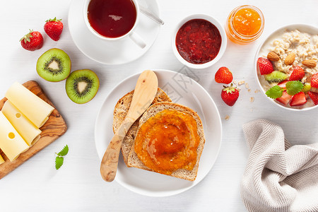 有燕麦粥草莓坚果吐司酱和茶的早餐背景图片