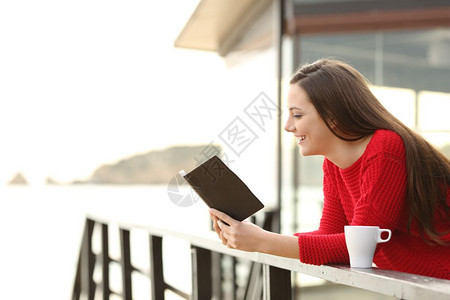 在阳台看书的侧面肖像图片