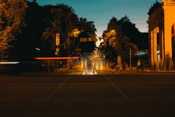 在夜间城市上行驶汽车和人行走模糊图片