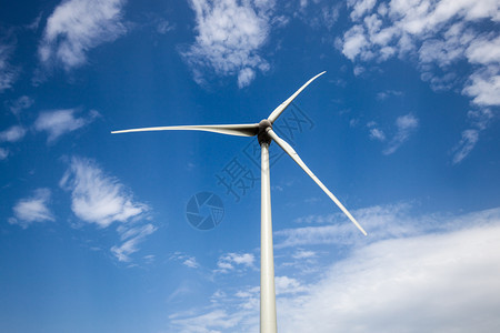 蓝云天空上风力涡轮主旋翼图片