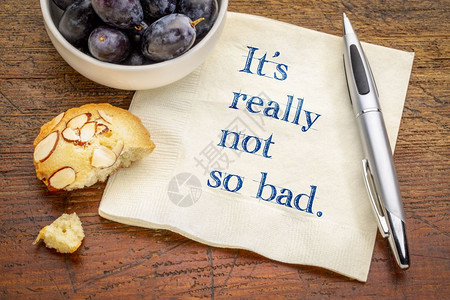 它真的不是那么糟糕肯定的文本在餐巾纸上与葡萄和饼干图片