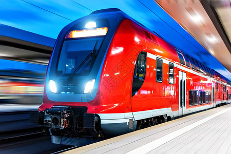 具有创意的抽象铁路旅行和运输工业概念现代红色高速电动客上乘双层火车晚上在照亮的火车站平台运动效果模糊图片